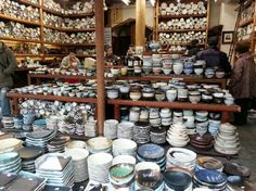 many plates and bowls are on display in a store