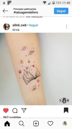 an open book tattoo on the right arm with stars and hearts coming out of it