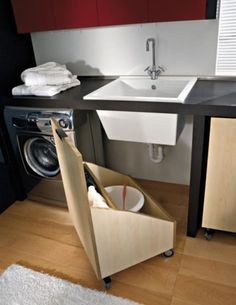 a washer and dryer in a small room with wood flooring on the ground