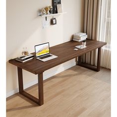 a laptop computer sitting on top of a wooden desk next to a book shelf and window