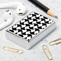 an electronic device sitting on top of a table next to ear buds and paper clips