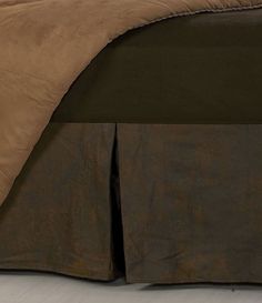 a bed with a brown comforter on top of it