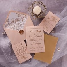 the wedding stationery is laid out on top of each other, including an envelope with a wax stamp