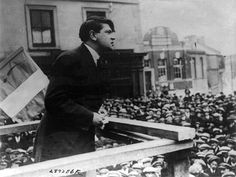 a black and white photo of a man standing in front of a crowd