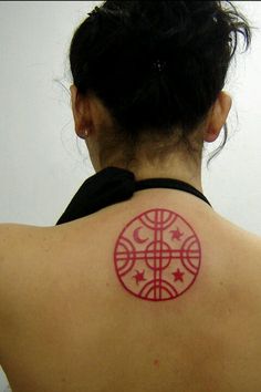 a woman with a red tattoo on her back shoulder and neck is looking at the camera