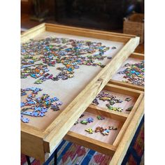 a wooden table with drawers filled with puzzle pieces