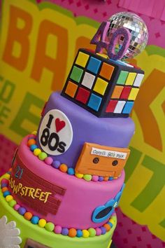 a multi - tiered cake with rubik's on top is decorated in bright colors