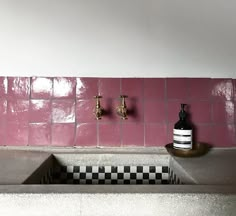 a sink with two faucets and soap dispensers on the wall