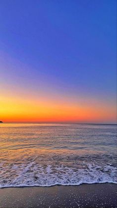 the sun is setting over the water at the beach