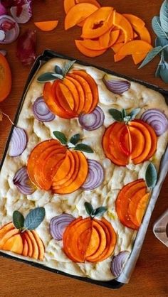 a baking dish with carrots and onions on it, surrounded by other food items