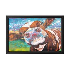 a painting of a cow is hanging on the wall next to a vase with flowers