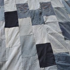 an unmade quilt with black and grey squares on it