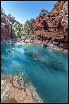 the water is very blue and clear in this area with red rocks on either side