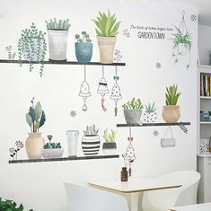 there are many potted plants on the shelves above the table and chairs in this room