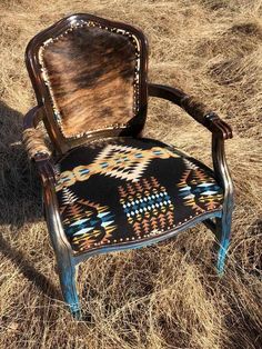 an old chair sitting on top of dry grass