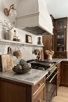 a kitchen with marble counter tops and wooden cabinetry, along with an oven hood