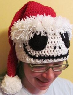 a man wearing a red and white crocheted santa hat