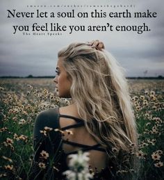 a woman with long blonde hair standing in a field full of flowers and looking at the sky