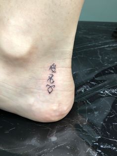 a small foot tattoo with the word love written in cursive writing on it