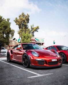 two red sports cars parked next to each other in a parking lot