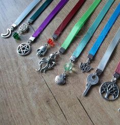 several different colored lanyards are lined up on a wooden table with charms attached to them