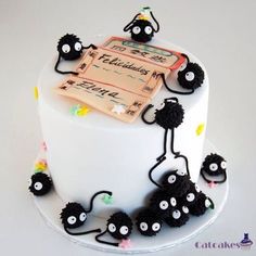 a white cake with black frosting and lots of small black monsters on the top