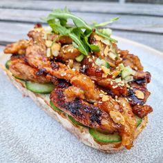 a sandwich with chicken, cucumber and sesame seeds