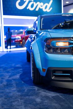 the front end of a blue chevrolet camaro at an auto show