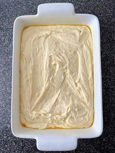 a white bowl filled with batter sitting on top of a counter