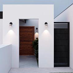 an entrance to a modern house with two lights on the outside and one light on the inside