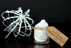 a small jar filled with whipped cream sitting on top of a table next to a tag