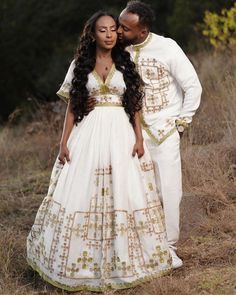 a man and woman dressed in white standing next to each other