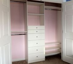 an empty room with white closets and pink walls