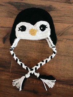 a knitted penguin hat sitting on top of a wooden floor