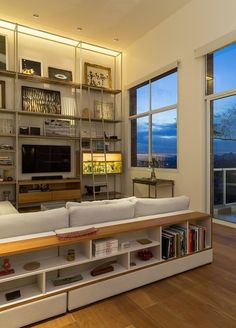 a living room filled with furniture and large windows