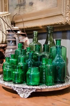 many green glass jars are on a tray