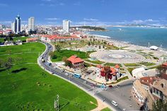 an aerial view of a city and the ocean with cars driving on it's road