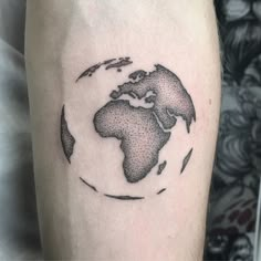 a black and white photo of the world on someone's arm