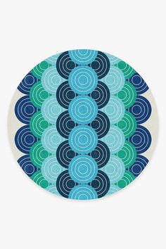 a blue and green circular plate with circles on the front, in an abstract pattern