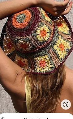 a woman wearing a crocheted hat with her hands on the top of her head