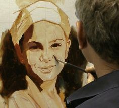 a man is painting a woman's face on a canvas