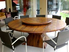 a wooden table with chairs around it in a living room next to a patio area