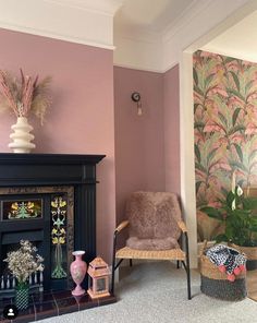 a living room filled with furniture and a fire place in front of a pink wall