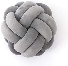 a gray and white knot pillow sitting on top of a table