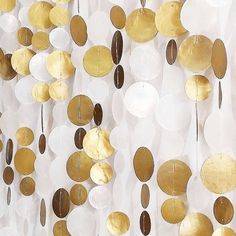 a group of gold and white circles hanging from the side of a wall next to each other