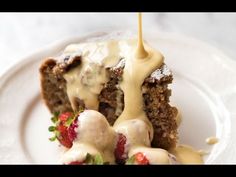 a piece of cake covered in icing and strawberries on top of a white plate