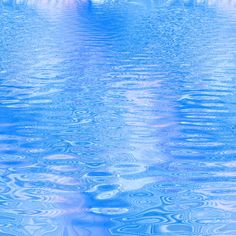 an image of water that looks like it is reflecting the sky and clouds in blue