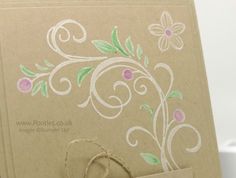 a close up of a brown card with flowers on it and a tag hanging from the front