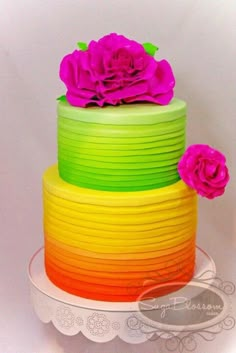 there is a multi colored cake with flowers on top