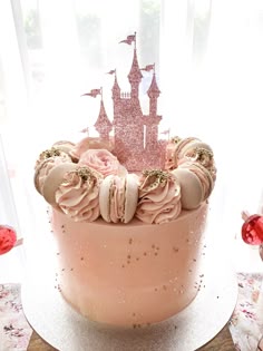 there is a cake that has pink frosting on it with a castle in the background